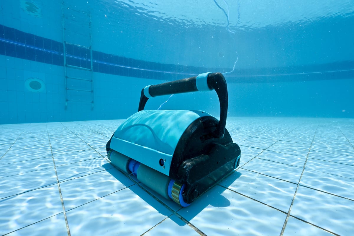 Robotic pool cleaner scrubbing the walls and floor of a pool